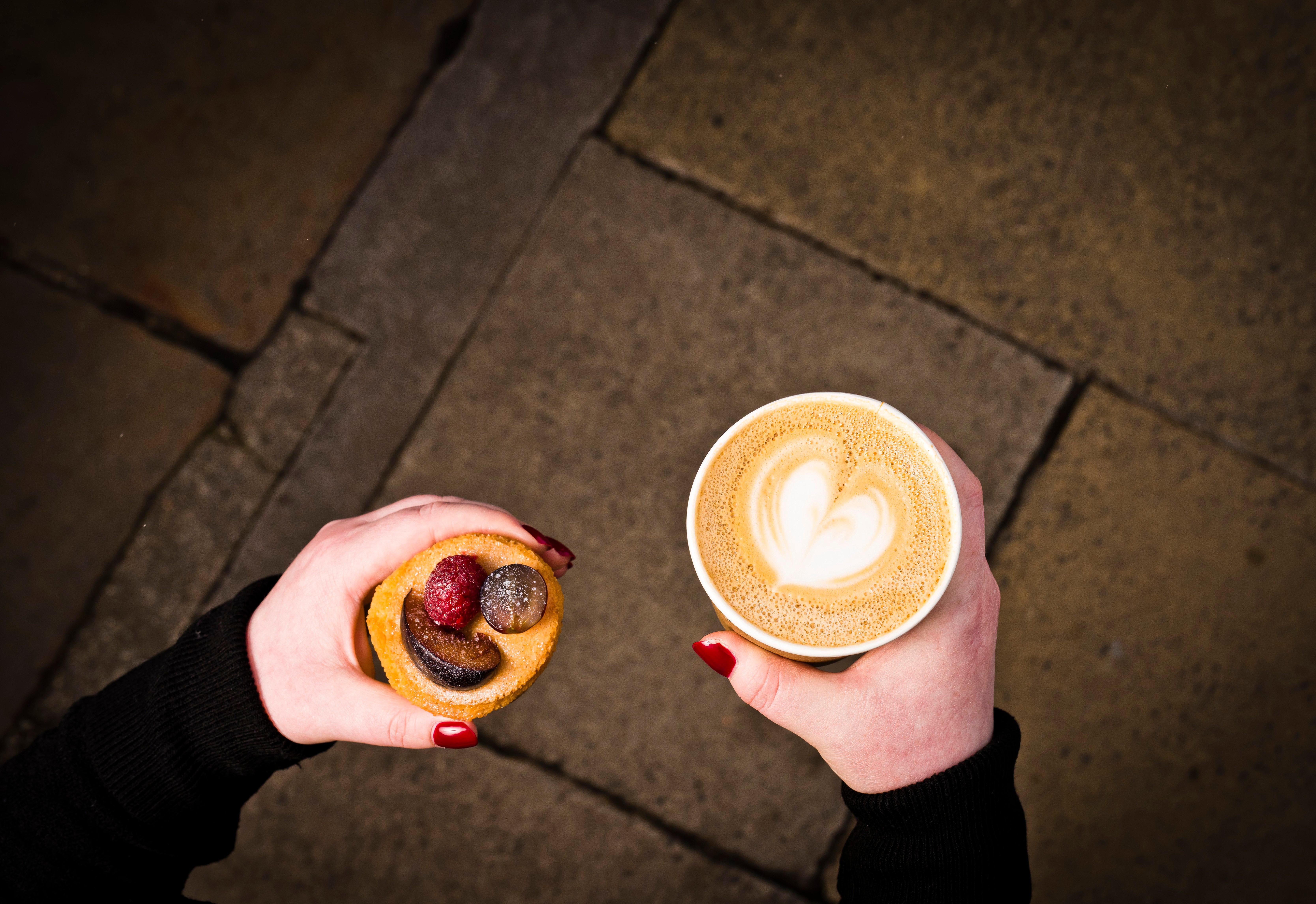 爱丁堡乔治酒店 外观 照片 A woman holding a coffee and a doughnut